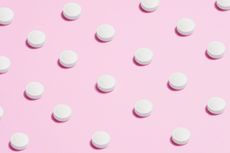 White pills on pink